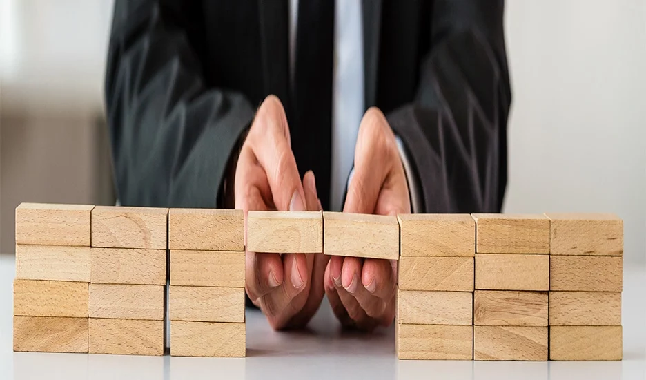 Mergers and acquisitions streamlining being shown using wooden blocks