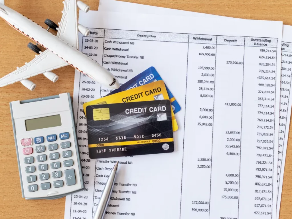 Air travel expenses sheet on a table with calculator and credit cards
